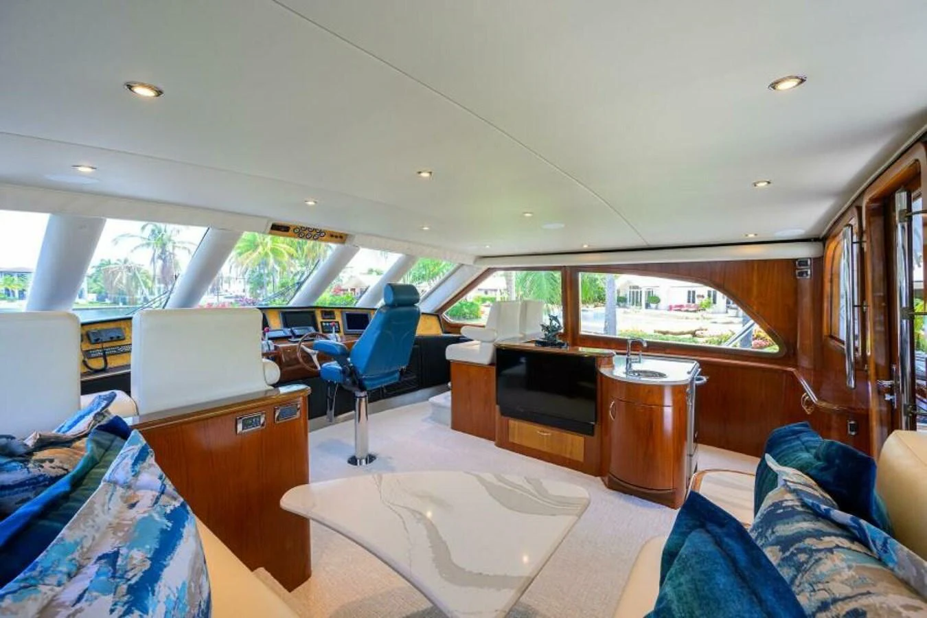 The salon features luxurious seating, a modern helm, and expansive windows offering panoramic views. aboard JUNIOR Yacht for Sale