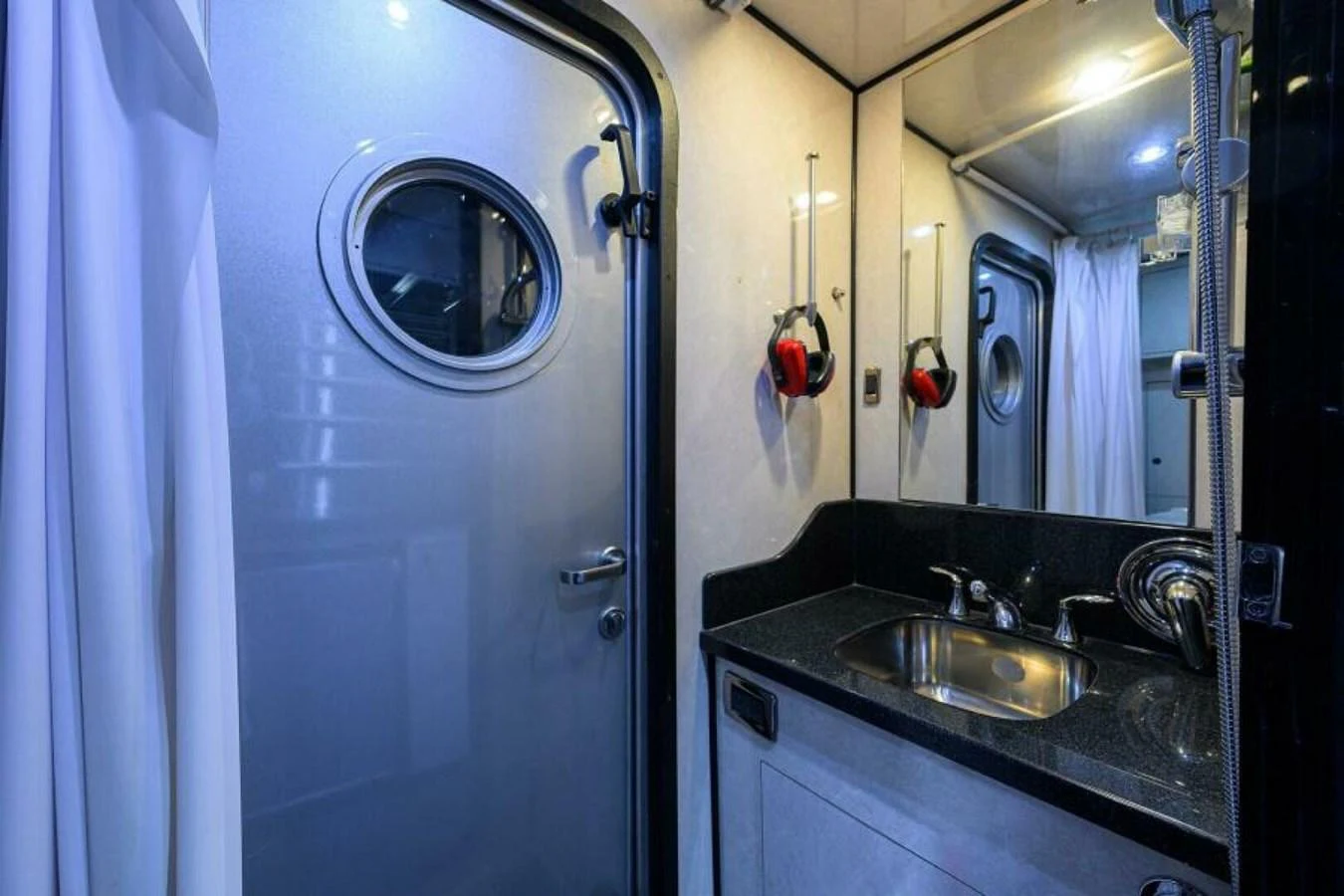 A sleek and modern yacht bathroom with a porthole window and stylish fixtures. aboard JUNIOR Yacht for Sale
