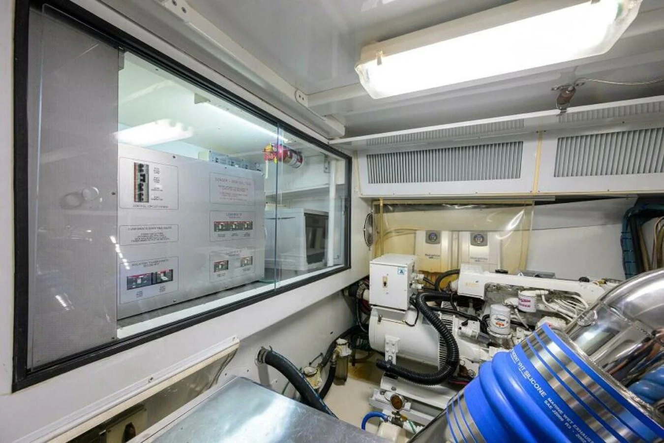 The image showcases the yacht's well-maintained engine room with visible machinery and control panels. aboard JUNIOR Yacht for Sale