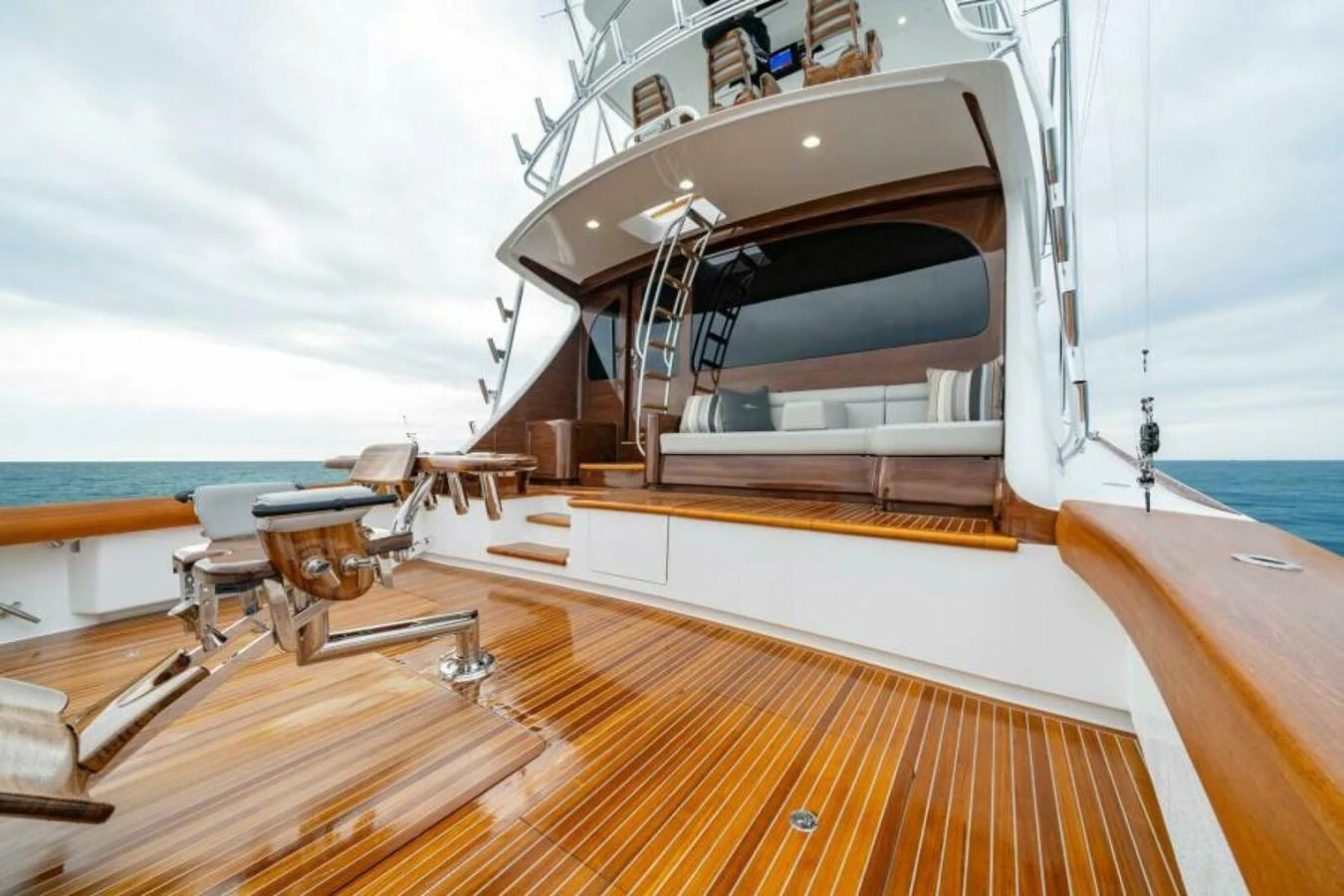 The yacht's aft deck features luxurious wooden flooring and comfortable seating, perfect for relaxation and socializing. aboard 2027 VIKING 82C Yacht for Sale