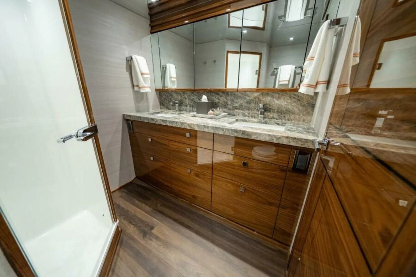 A luxurious yacht bathroom featuring a sleek vanity with ample storage and a spacious shower. aboard 2027 VIKING 82C Yacht for Sale