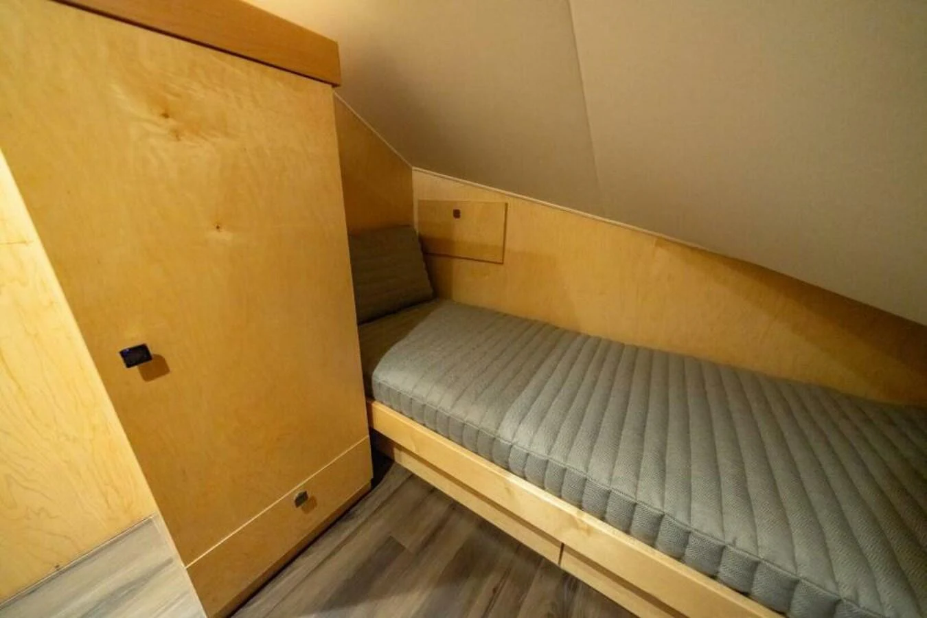A cozy crew cabin with a single bed and wooden furnishings. aboard 2027 VIKING 82C Yacht for Sale