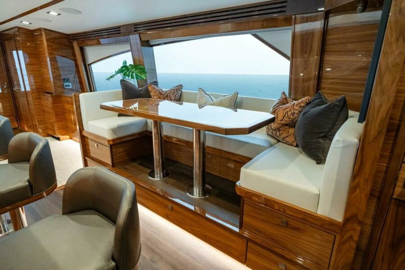 The yacht's dining area features a polished wooden table surrounded by plush seating with ocean views. aboard 2027 VIKING 82C Yacht for Sale