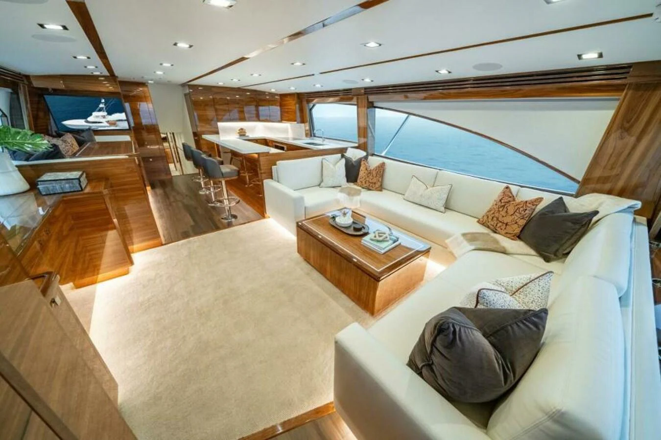 The salon features luxurious seating with a modern and elegant design, complemented by large windows offering stunning ocean views. aboard 2027 VIKING 82C Yacht for Sale