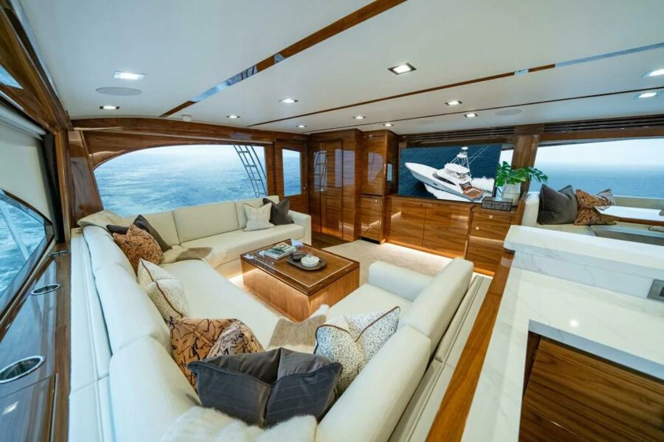 The salon features luxurious seating with panoramic ocean views. aboard 2027 VIKING 82C Yacht for Sale