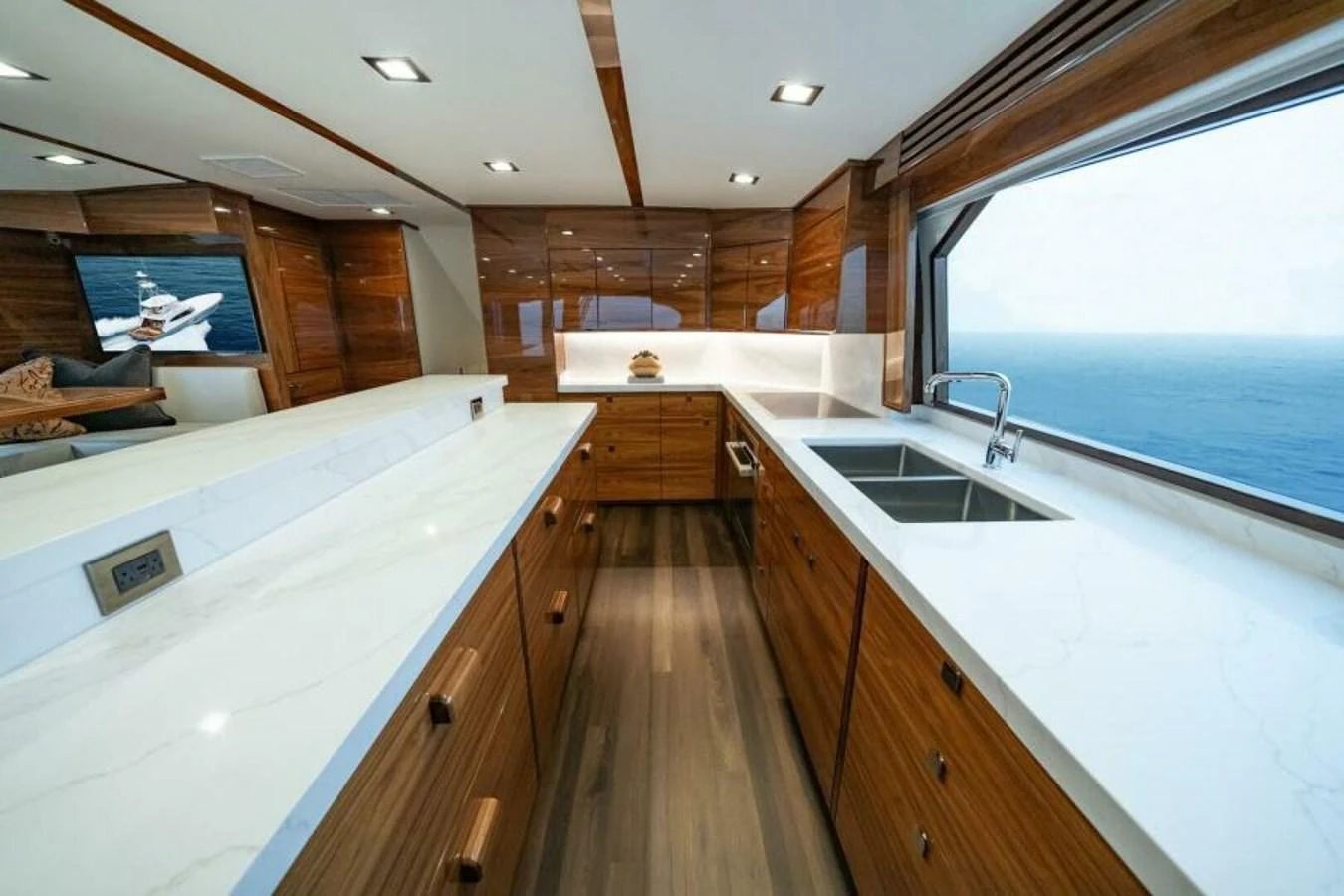 The galley features sleek wooden cabinetry, modern appliances, and expansive ocean views. aboard 2027 VIKING 82C Yacht for Sale