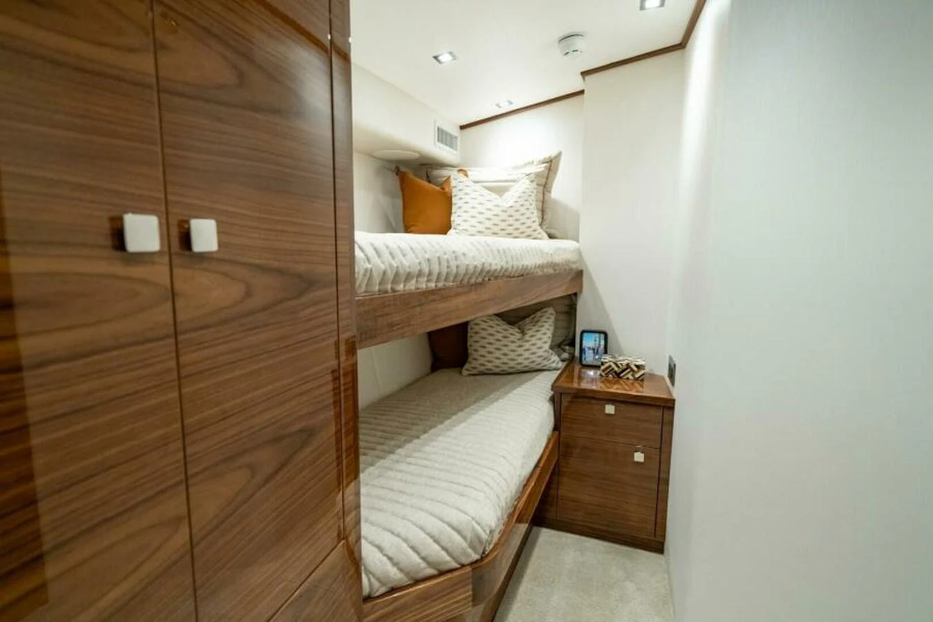 The cozy guest cabin features stylish wood paneling and comfortable bunk beds. aboard 2027 VIKING 82C Yacht for Sale