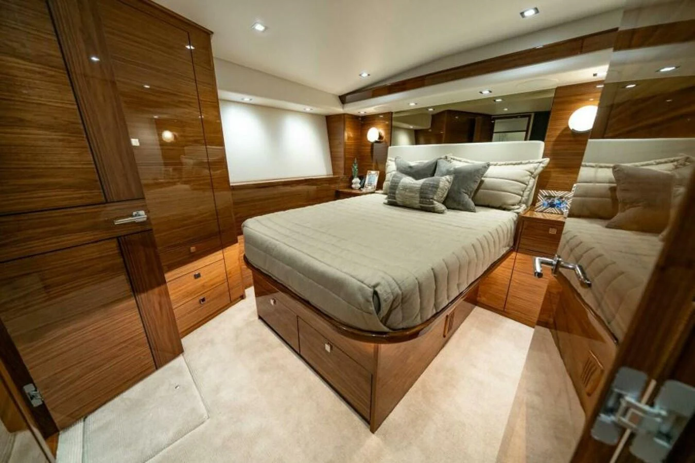 The stateroom features a luxurious bed with elegant wooden cabinetry and soft lighting. aboard 2027 VIKING 82C Yacht for Sale