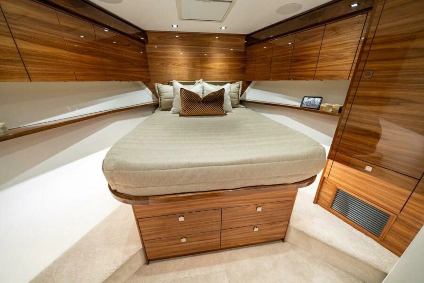The stateroom features a luxurious bed with rich wooden cabinetry and modern lighting. aboard 2027 VIKING 82C Yacht for Sale