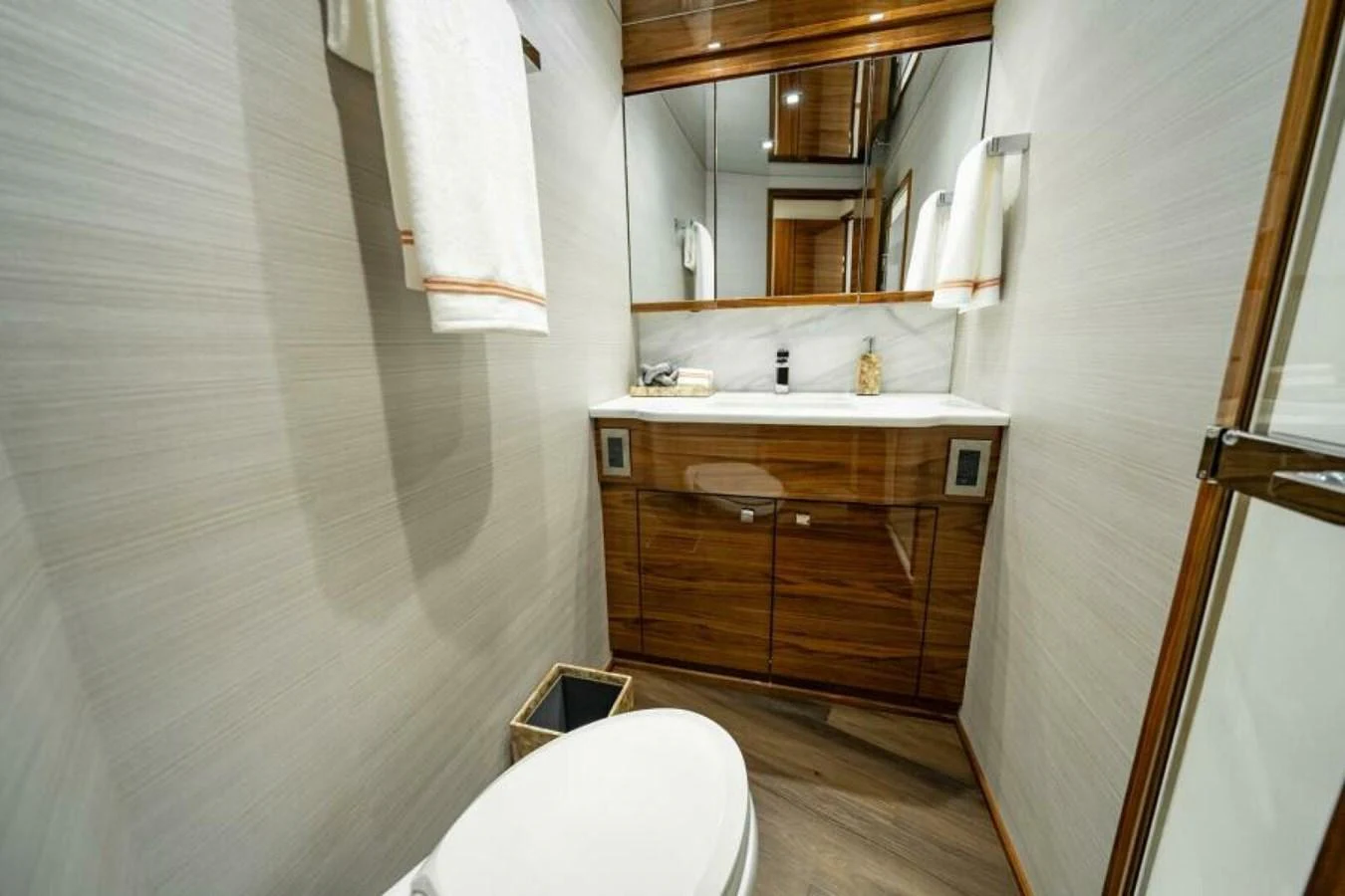 The yacht's bathroom features modern fixtures and elegant wood cabinetry. aboard 2027 VIKING 82C Yacht for Sale