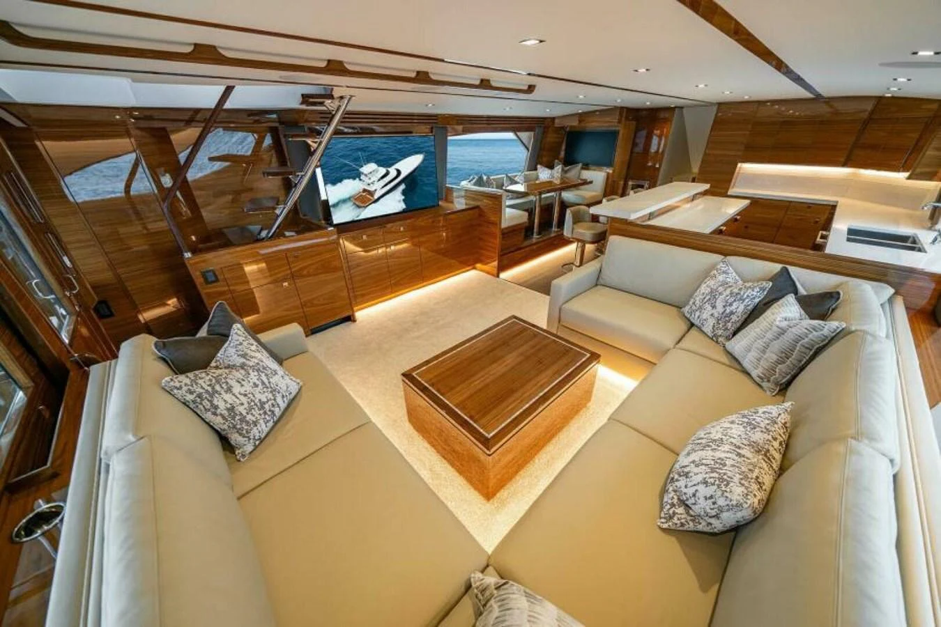 The salon features plush seating, a wooden coffee table, and a large TV, creating a luxurious and inviting atmosphere. aboard 2027 VIKING 82SB Yacht for Sale
