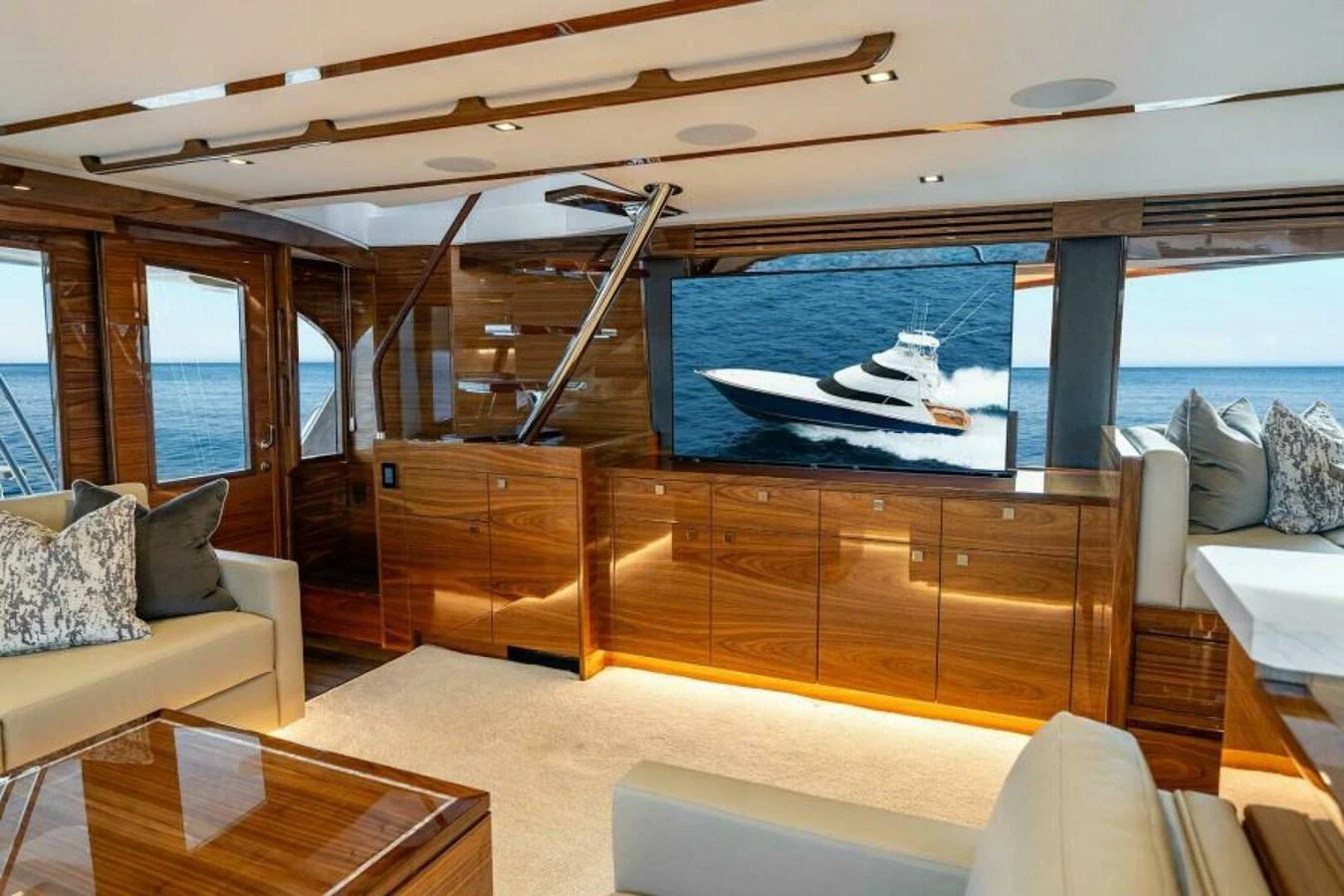 The salon features luxurious seating and a large TV with a view of the sea. aboard 2027 VIKING 82SB Yacht for Sale