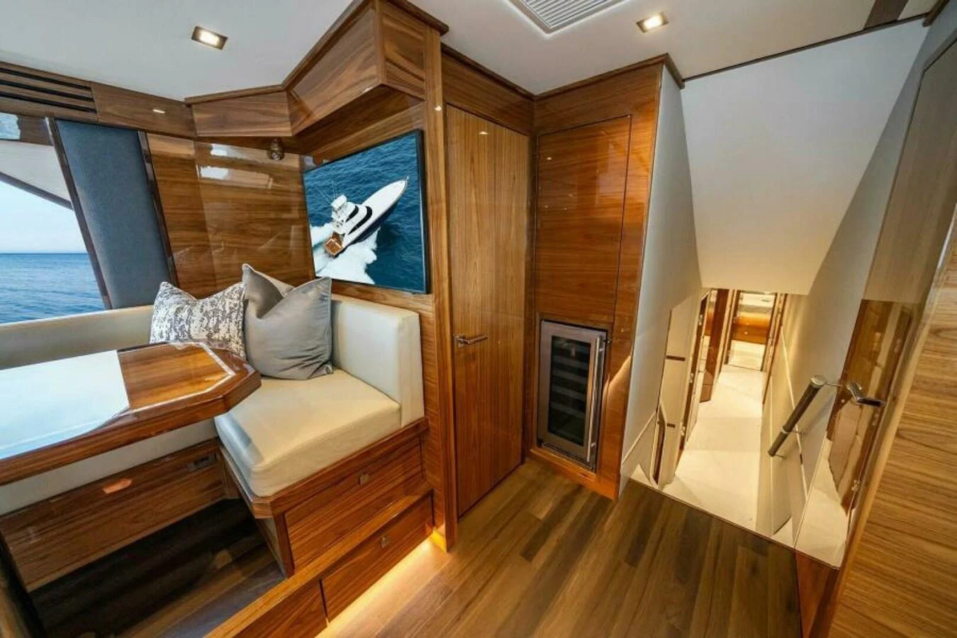 The yacht's interior features a cozy seating area with a wooden table and a hallway leading to other rooms. aboard 2027 VIKING 82SB Yacht for Sale