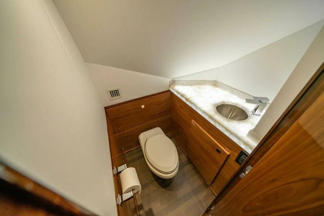 The yacht's head features a modern design with wooden cabinetry and a sleek sink. aboard 2027 VIKING 82SB Yacht for Sale