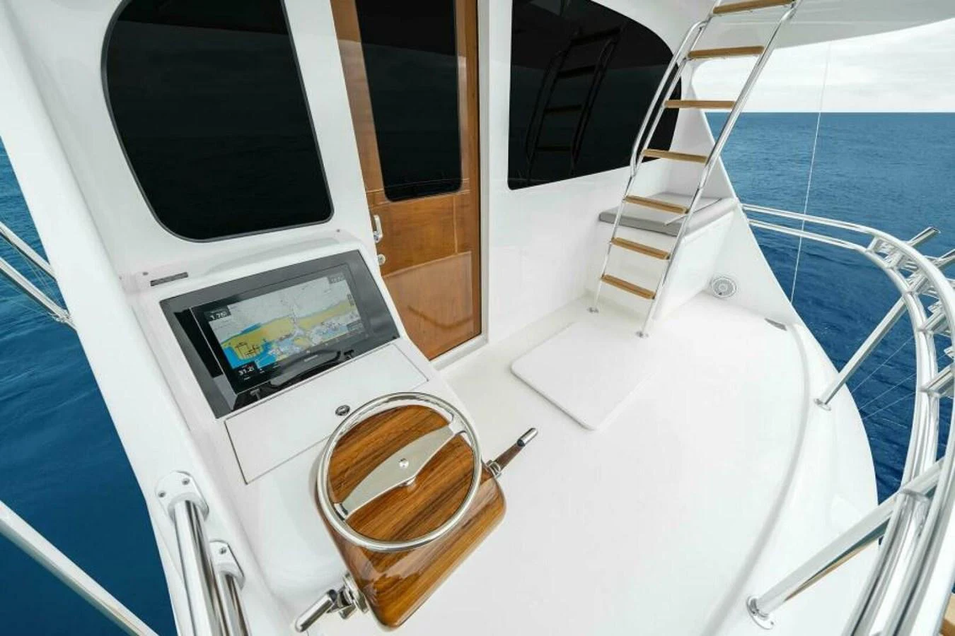 The flybridge offers a sleek navigation station with a modern helm and comfortable seating. aboard 2027 VIKING 82SB Yacht for Sale