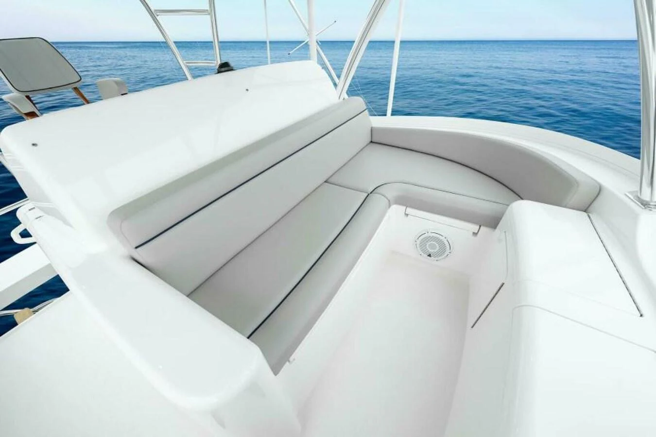 The yacht features a pristine white seating area with a serene ocean backdrop. aboard 2027 VIKING 82SB Yacht for Sale