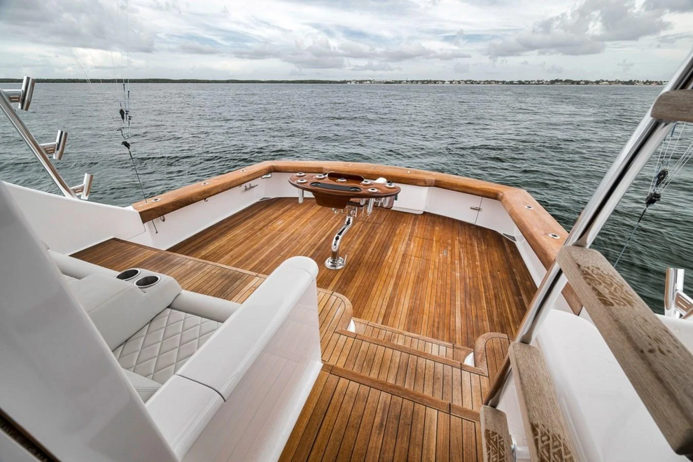 The yacht's aft deck features a spacious and elegant wooden floor with comfortable seating and a serene view of the water. aboard GENESIS Yacht for Sale