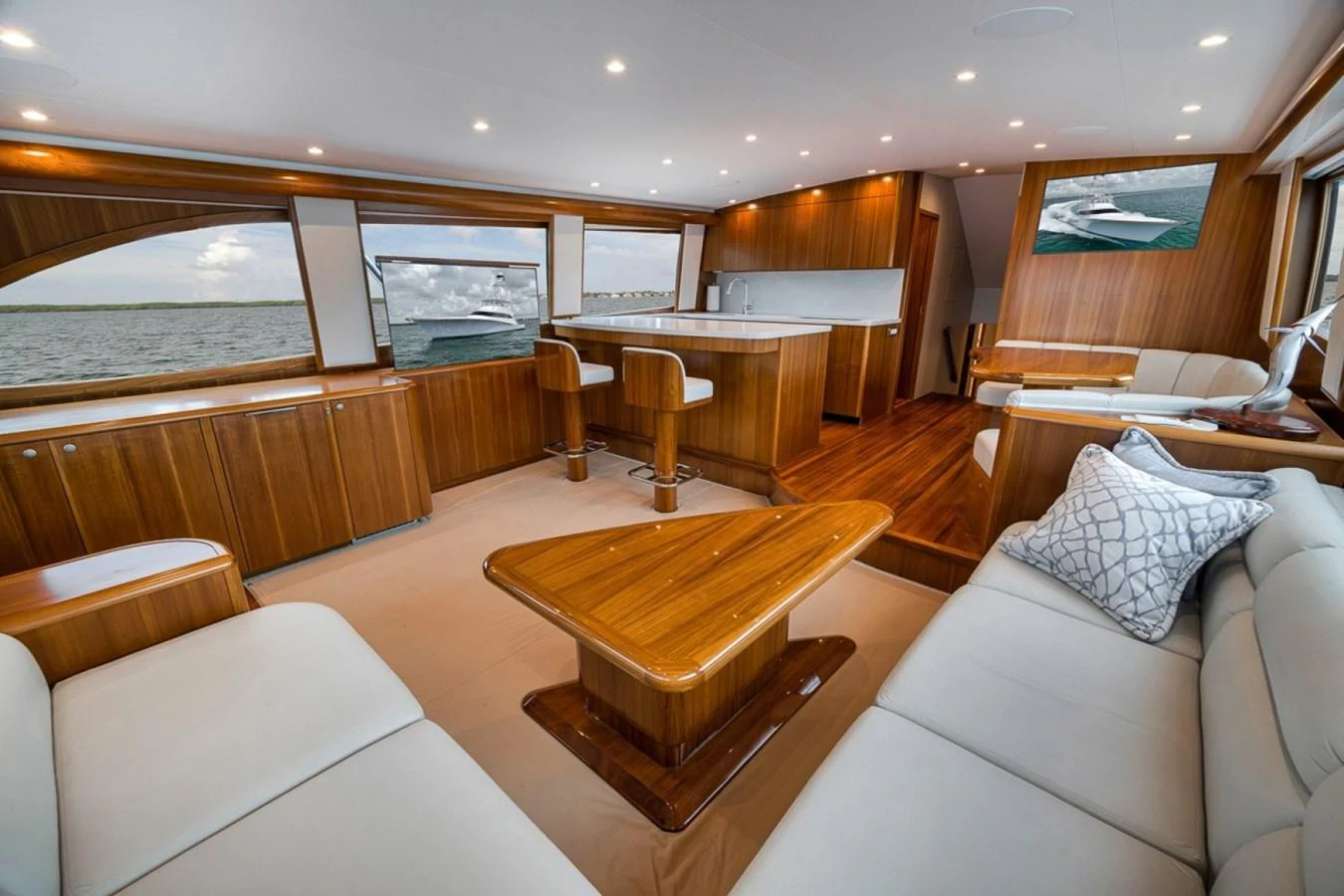 The salon features elegant wood paneling and plush seating with panoramic windows offering stunning views. aboard GENESIS Yacht for Sale