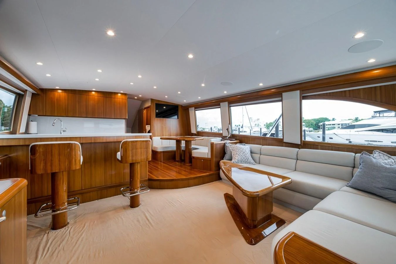 The salon features elegant wood finishes, plush seating, and ample natural light from large windows. aboard GENESIS Yacht for Sale