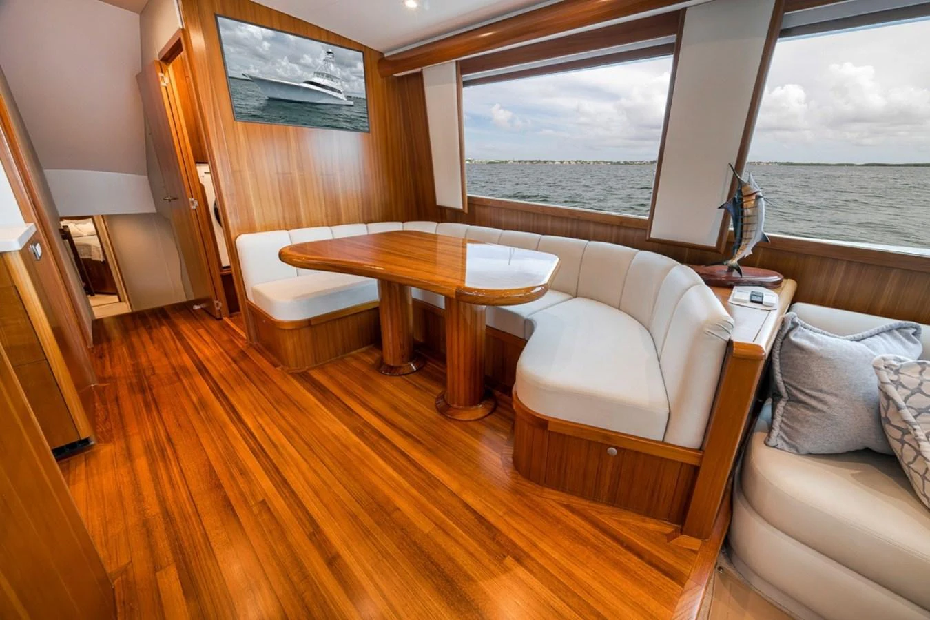 The salon features a cozy seating area with a polished wooden table and large windows offering stunning sea views. aboard GENESIS Yacht for Sale