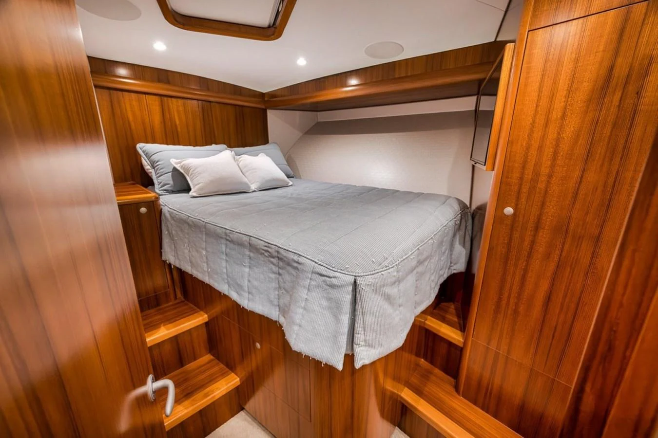 A cozy stateroom with rich wood paneling and a comfortable bed. aboard GENESIS Yacht for Sale