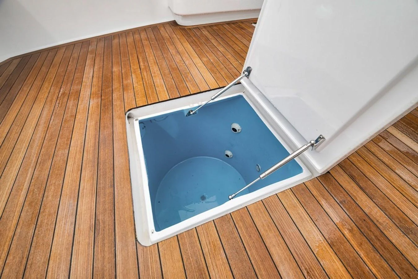 A close-up view of a yacht's deck hatch, showcasing the quality of the wood and the sleek design of the hatch mechanism. aboard GENESIS Yacht for Sale