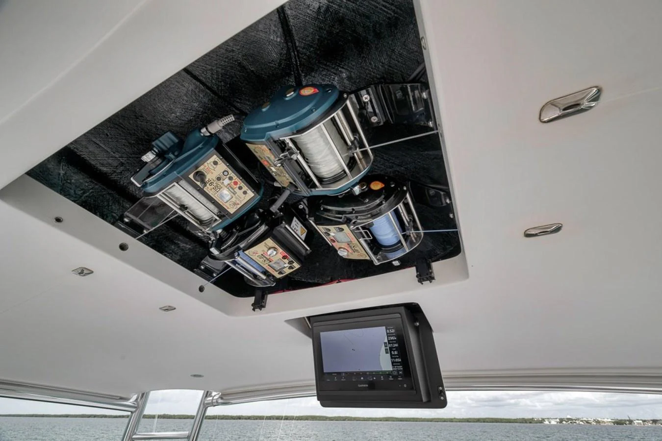 The image showcases the intricate details of the yacht's ceiling-mounted fishing equipment and a navigation screen. aboard GENESIS Yacht for Sale