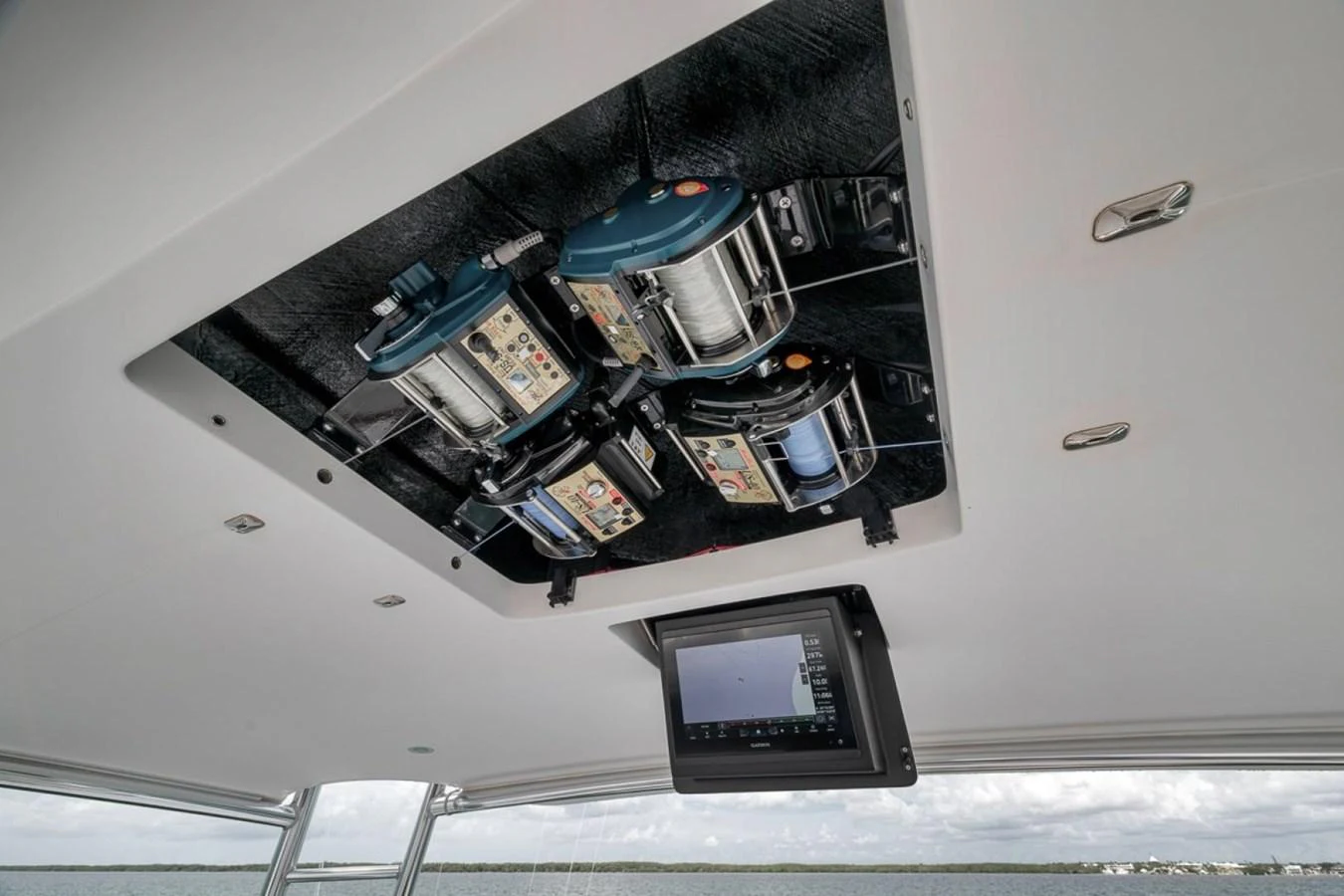 The image showcases the intricate ceiling-mounted fishing reel system on the yacht. aboard GENESIS Yacht for Sale