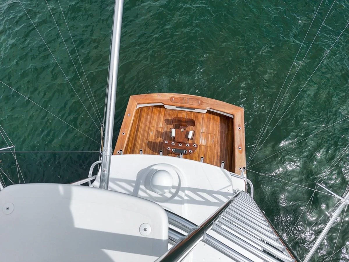 A view from above of the yacht's aft deck, showcasing its wooden finish and the surrounding water. aboard GENESIS Yacht for Sale