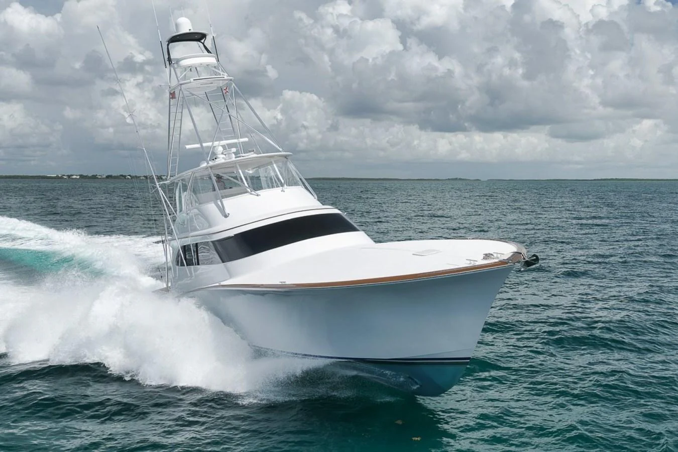 A sleek yacht cuts through the water under a cloudy sky. aboard GENESIS Yacht for Sale