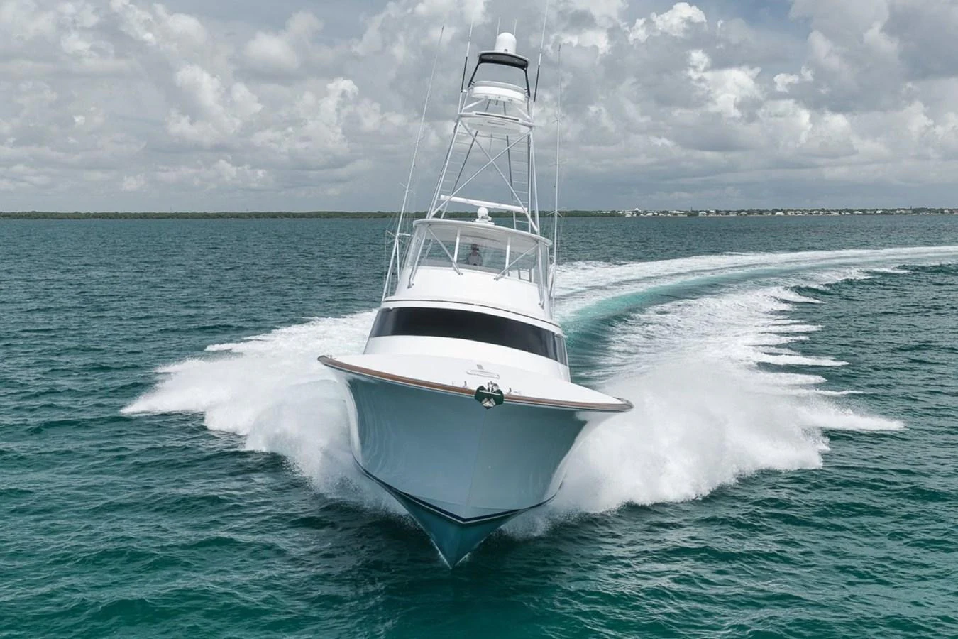 A sleek yacht cuts through the water at high speed, showcasing its powerful design. aboard GENESIS Yacht for Sale