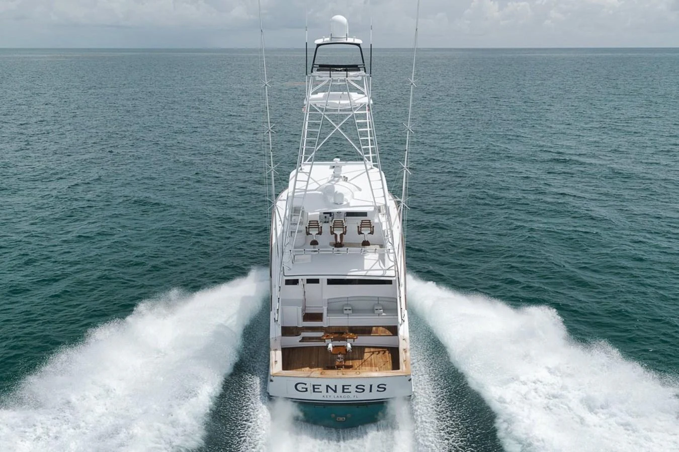 A sleek yacht cruises through the open sea, leaving a trail of white waves behind. aboard GENESIS Yacht for Sale
