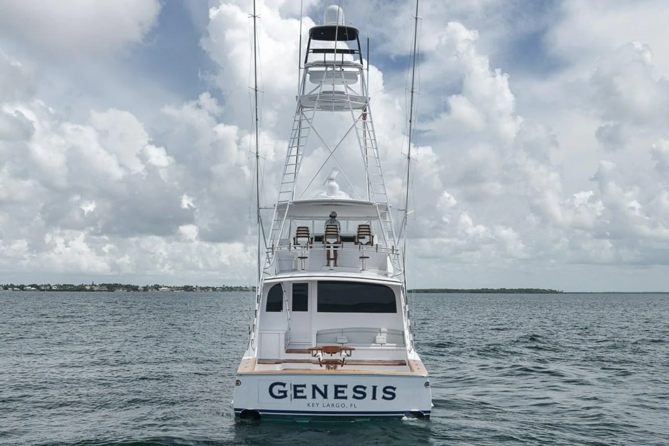 A sleek yacht is seen from the rear, showcasing its elegant design and spacious deck. aboard GENESIS Yacht for Sale
