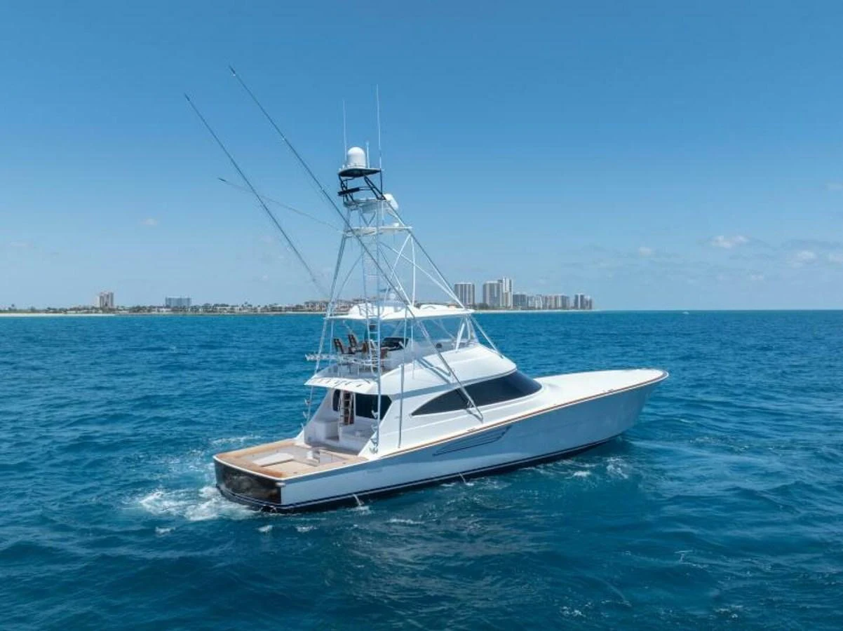 A sleek yacht cruises through clear blue waters under a bright sky. aboard 2027 VIKING 74C Yacht for Sale