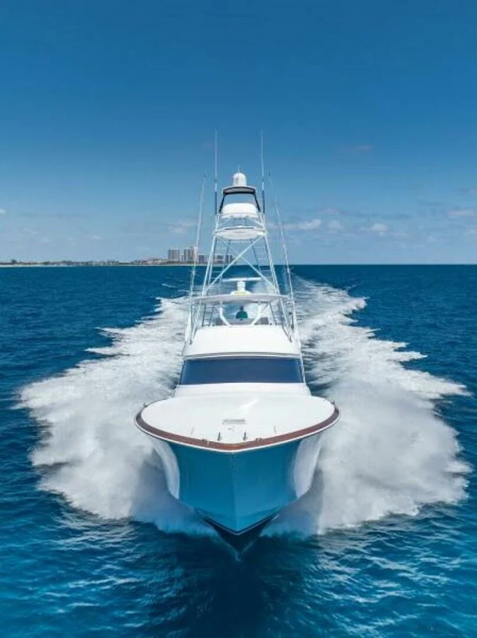 A sleek yacht cuts through the vibrant blue waters, showcasing its powerful design and elegance. aboard 2027 VIKING 74C Yacht for Sale