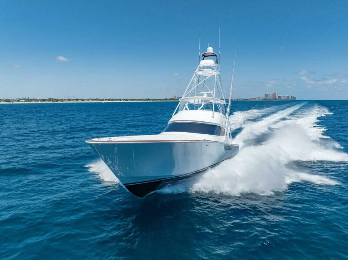 A sleek yacht cruises swiftly through the open water on a sunny day. aboard 2027 VIKING 74C Yacht for Sale