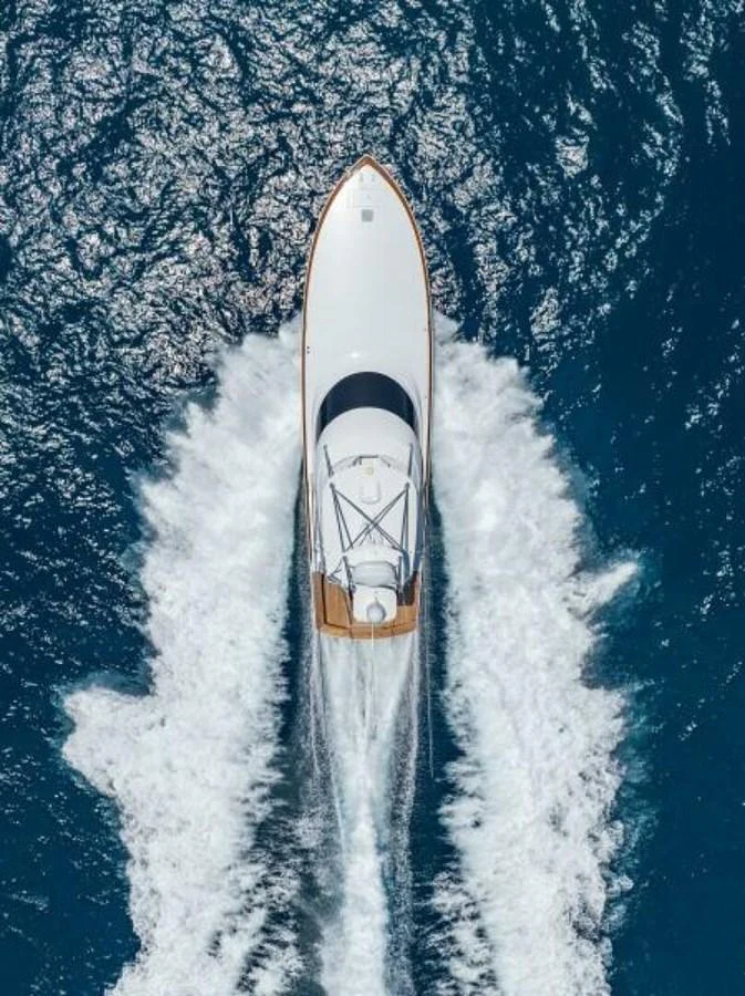 A sleek yacht cruises through the open water, leaving a trail of white wake behind. aboard 2027 VIKING 74C Yacht for Sale