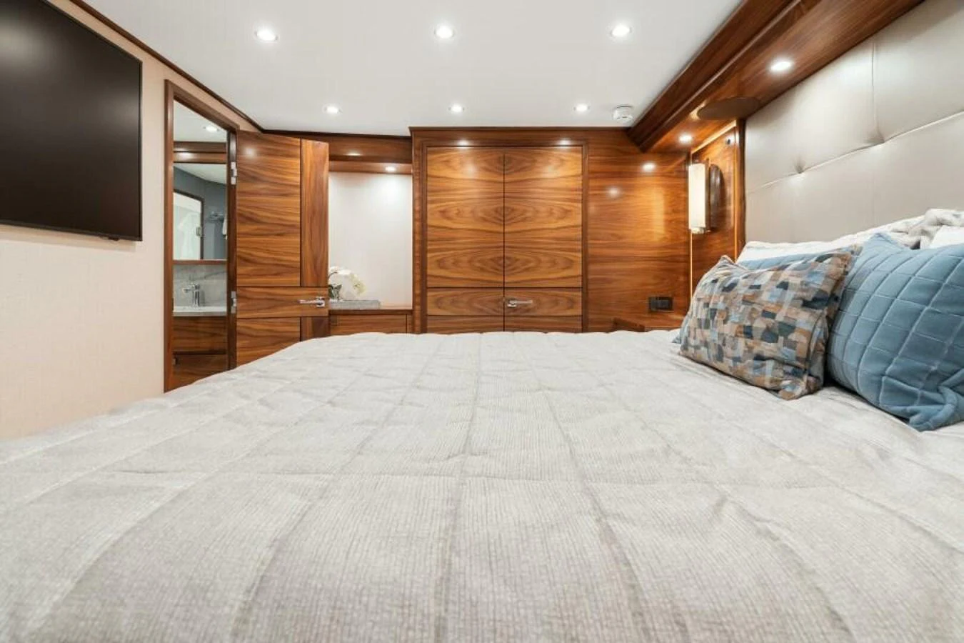 The stateroom features a luxurious bed with plush pillows and elegant wood paneling. aboard 2027 VIKING 74C Yacht for Sale