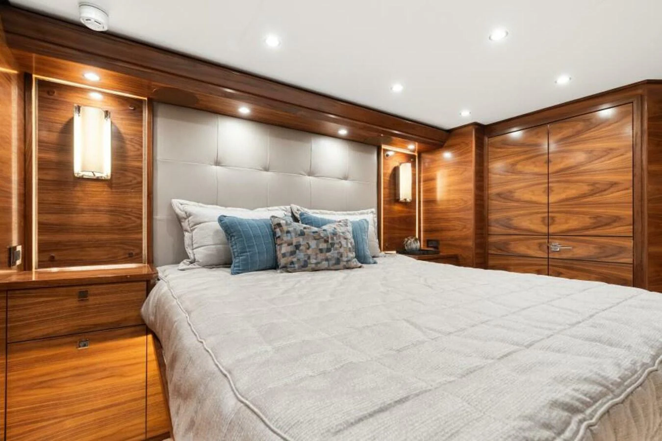 The master stateroom features luxurious wood paneling and plush bedding for ultimate comfort. aboard 2027 VIKING 74C Yacht for Sale