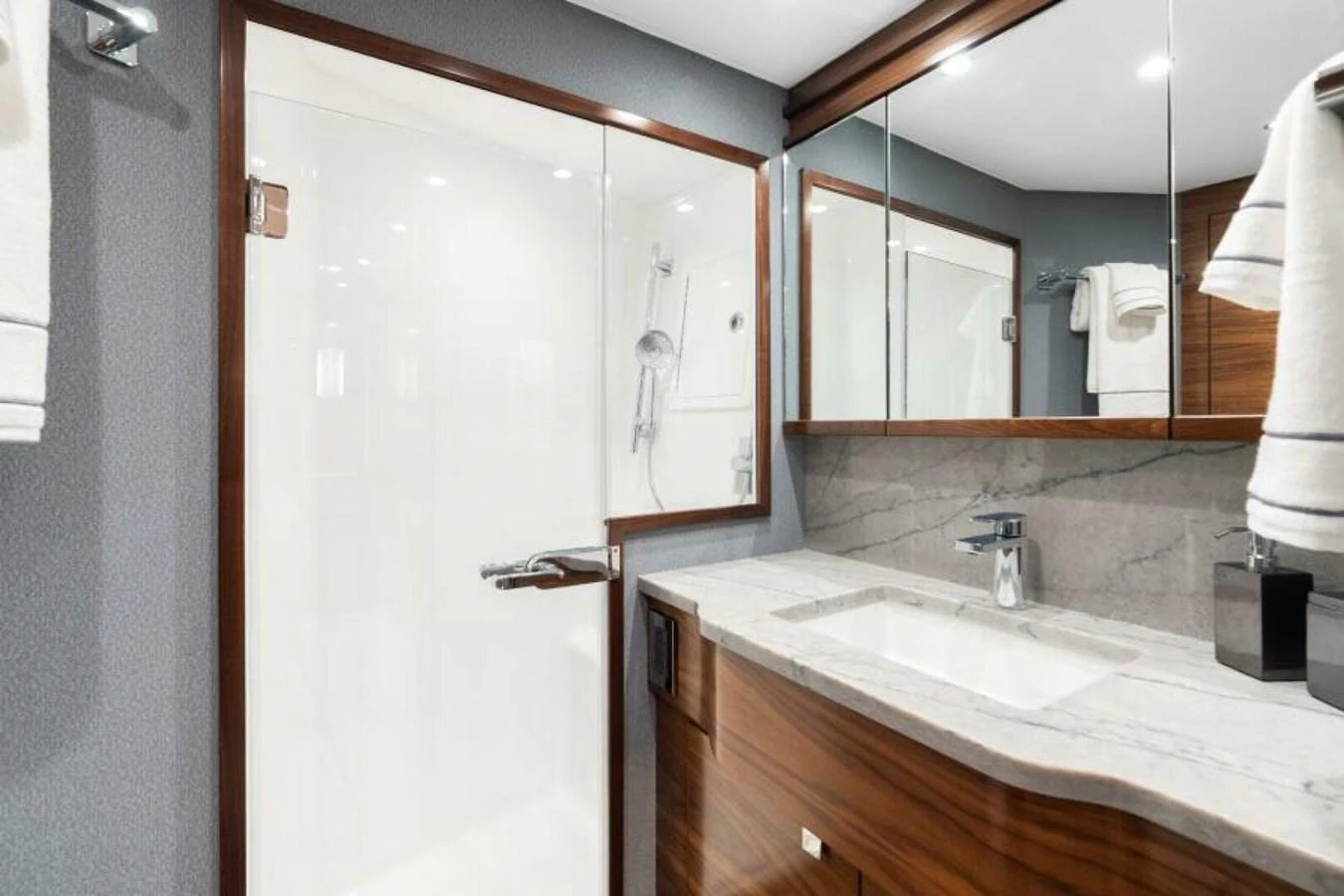 The bathroom features a sleek design with a modern sink and a spacious shower area. aboard 2027 VIKING 74C Yacht for Sale