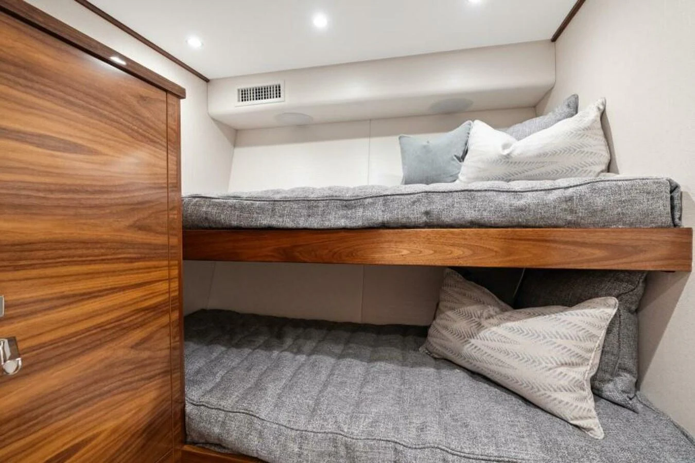 A cozy cabin with wooden bunk beds and plush bedding. aboard 2027 VIKING 74C Yacht for Sale