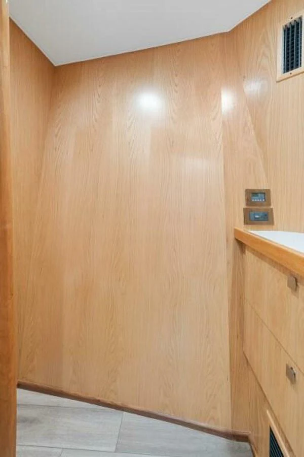 A compact interior space with wood-paneled walls and built-in storage. aboard 2027 VIKING 74C Yacht for Sale