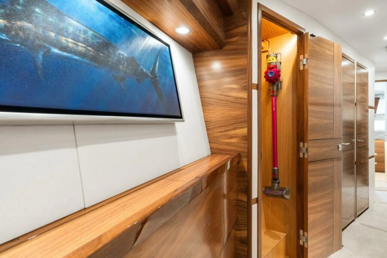 The yacht's interior features sleek wooden cabinetry and modern lighting, creating a warm and inviting atmosphere. aboard 2027 VIKING 74C Yacht for Sale