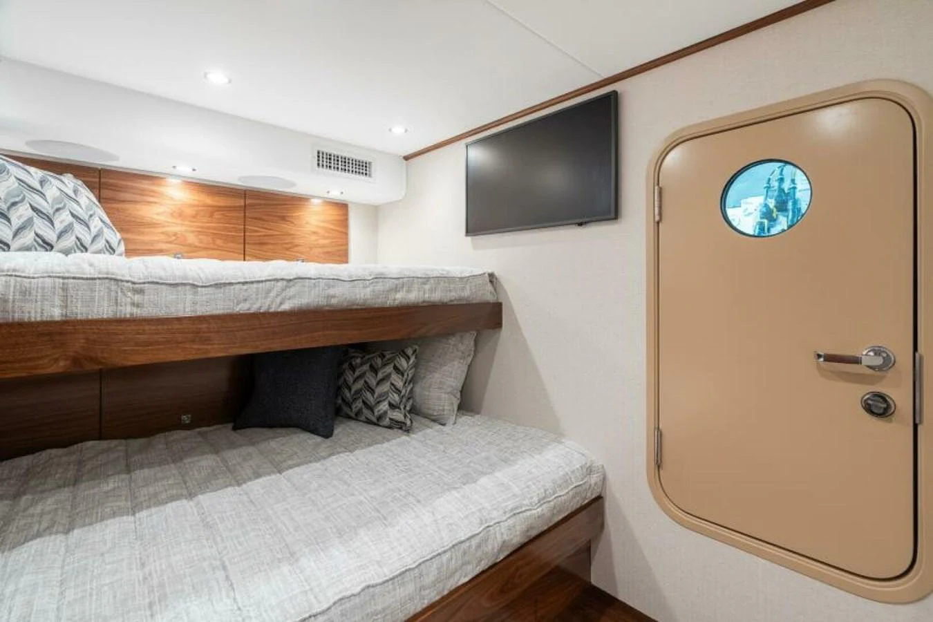 The guest cabin features cozy bunk beds and a porthole door, creating a comfortable and inviting space. aboard 2027 VIKING 74C Yacht for Sale