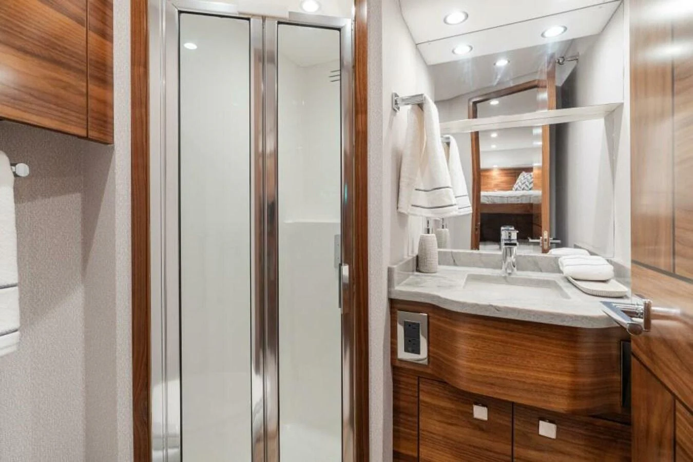 The yacht's bathroom features a sleek design with wooden accents and modern fixtures. aboard 2027 VIKING 74C Yacht for Sale