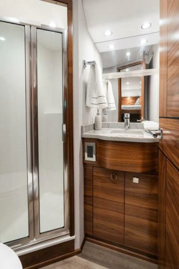 The yacht's bathroom features a sleek design with a glass shower enclosure and modern fixtures. aboard 2027 VIKING 74C Yacht for Sale