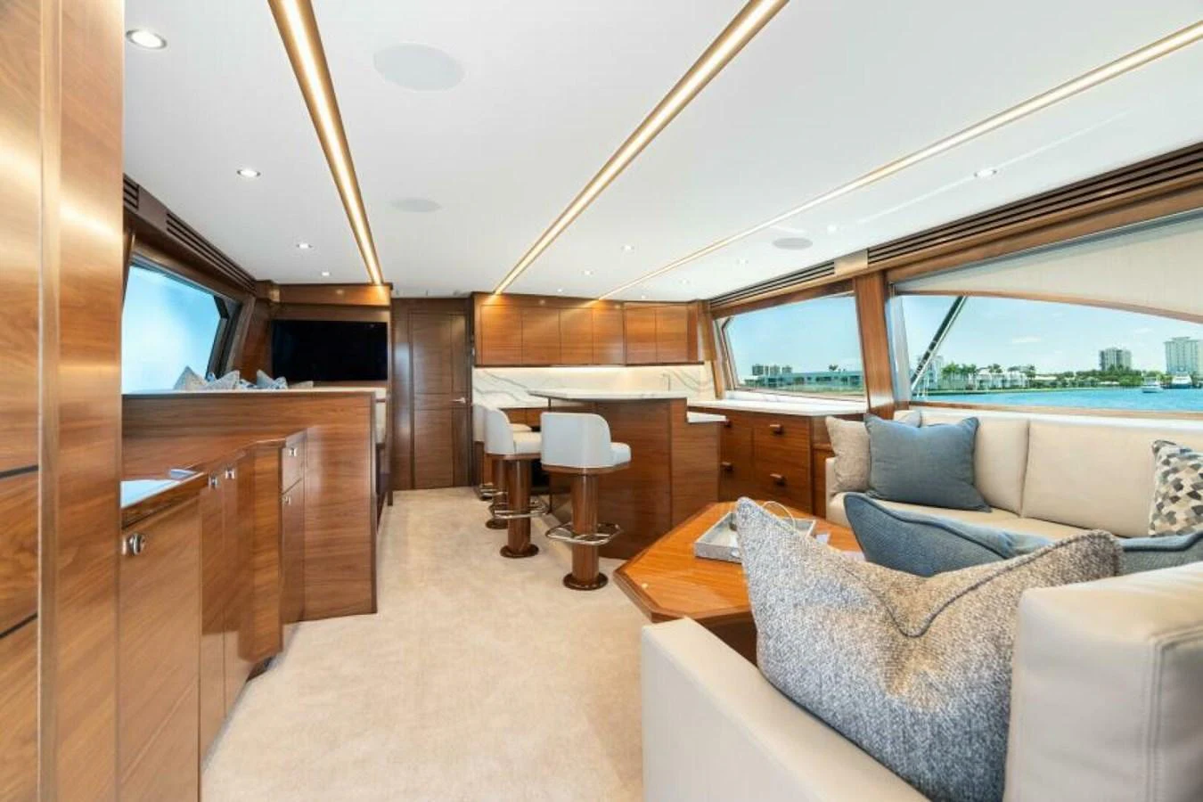 The salon features elegant wood finishes, plush seating, and expansive windows offering stunning views. aboard 2027 VIKING 74C Yacht for Sale