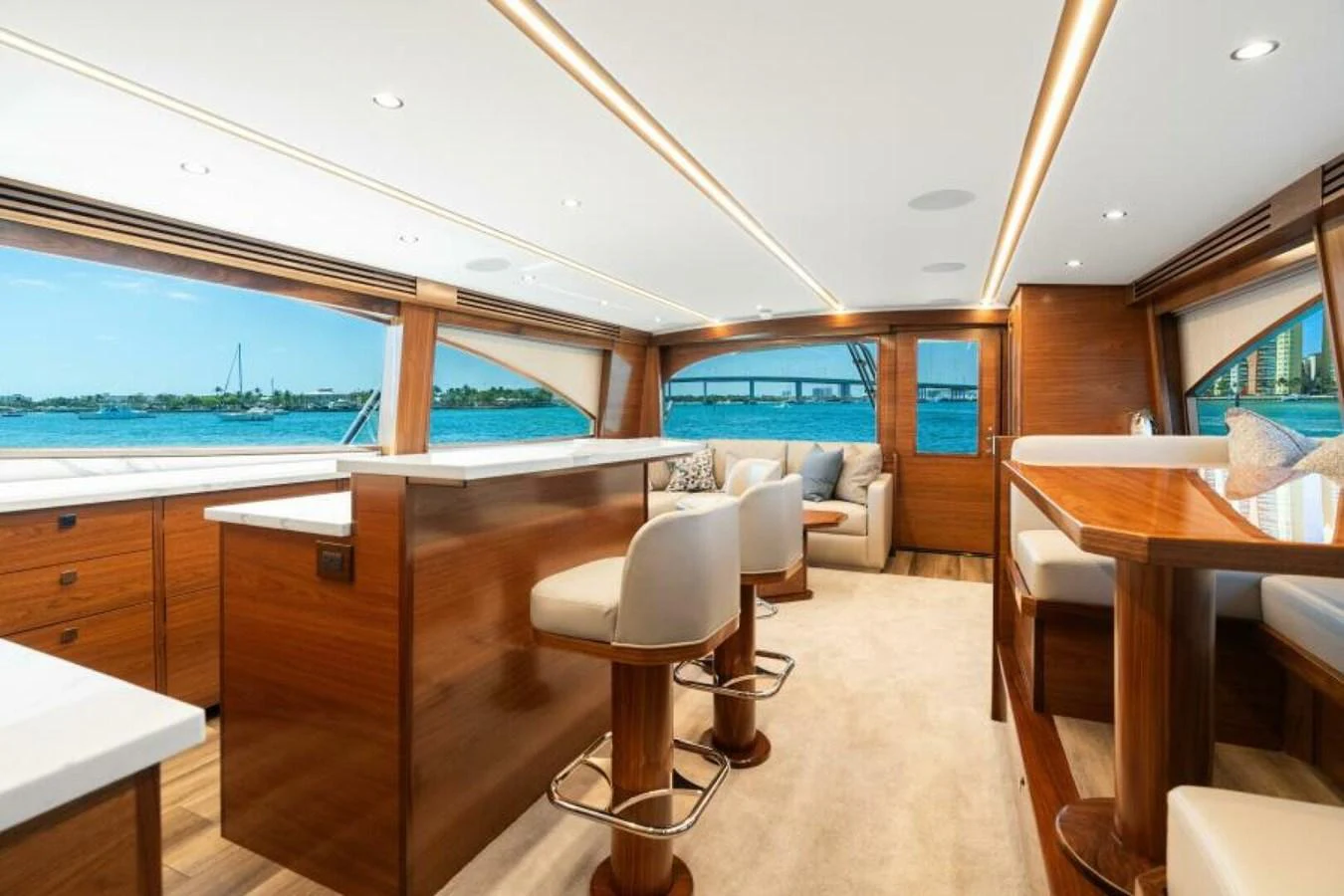The salon offers a spacious and elegant area with panoramic views and luxurious seating. aboard 2027 VIKING 74C Yacht for Sale