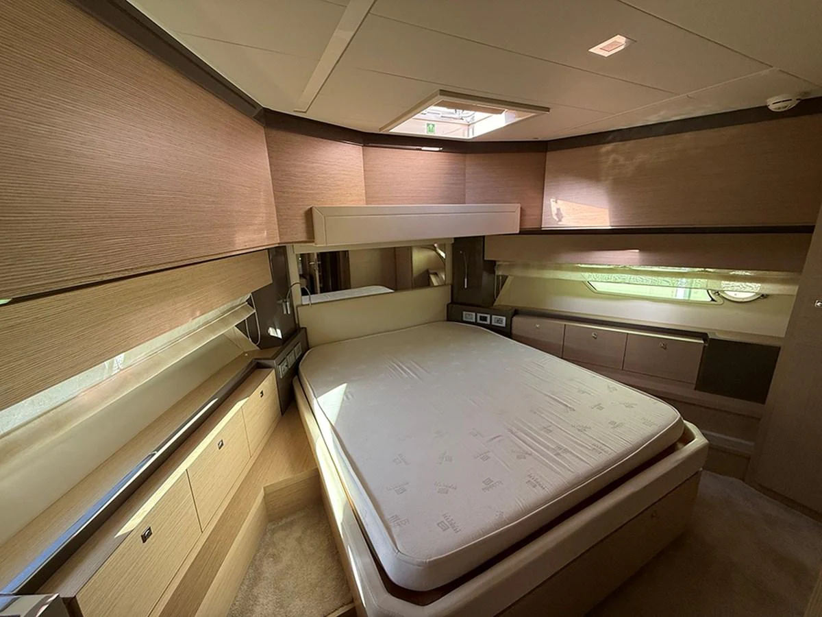 The stateroom features a spacious bed with ample natural light and elegant wood finishes. aboard LA LUNA Yacht for Sale