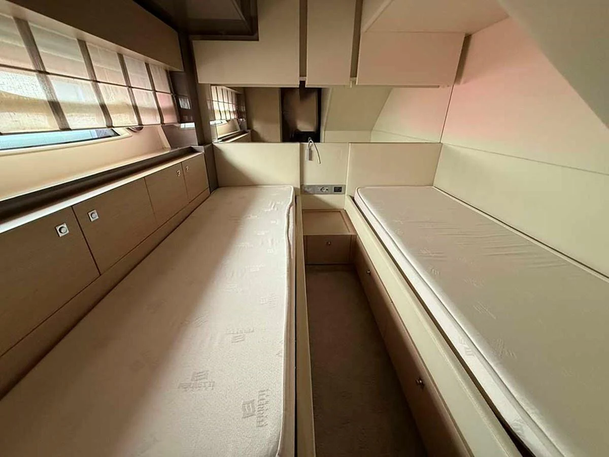 The guest cabin features twin beds with ample storage and natural light. aboard LA LUNA Yacht for Sale